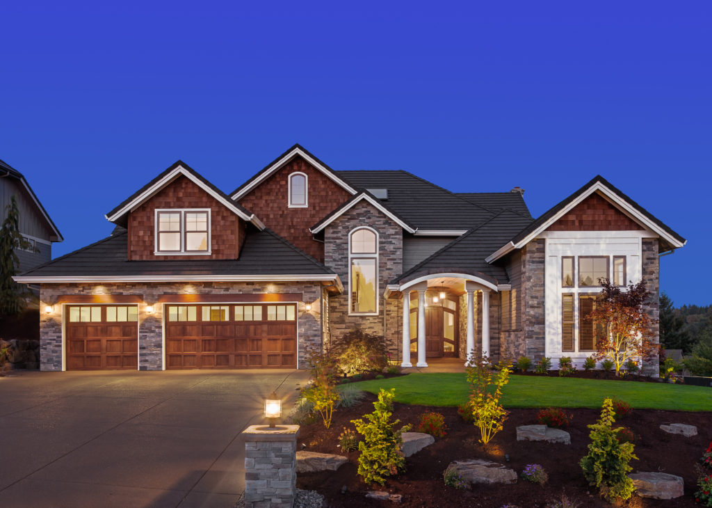 Beautiful Home Exterior with wood garage doors