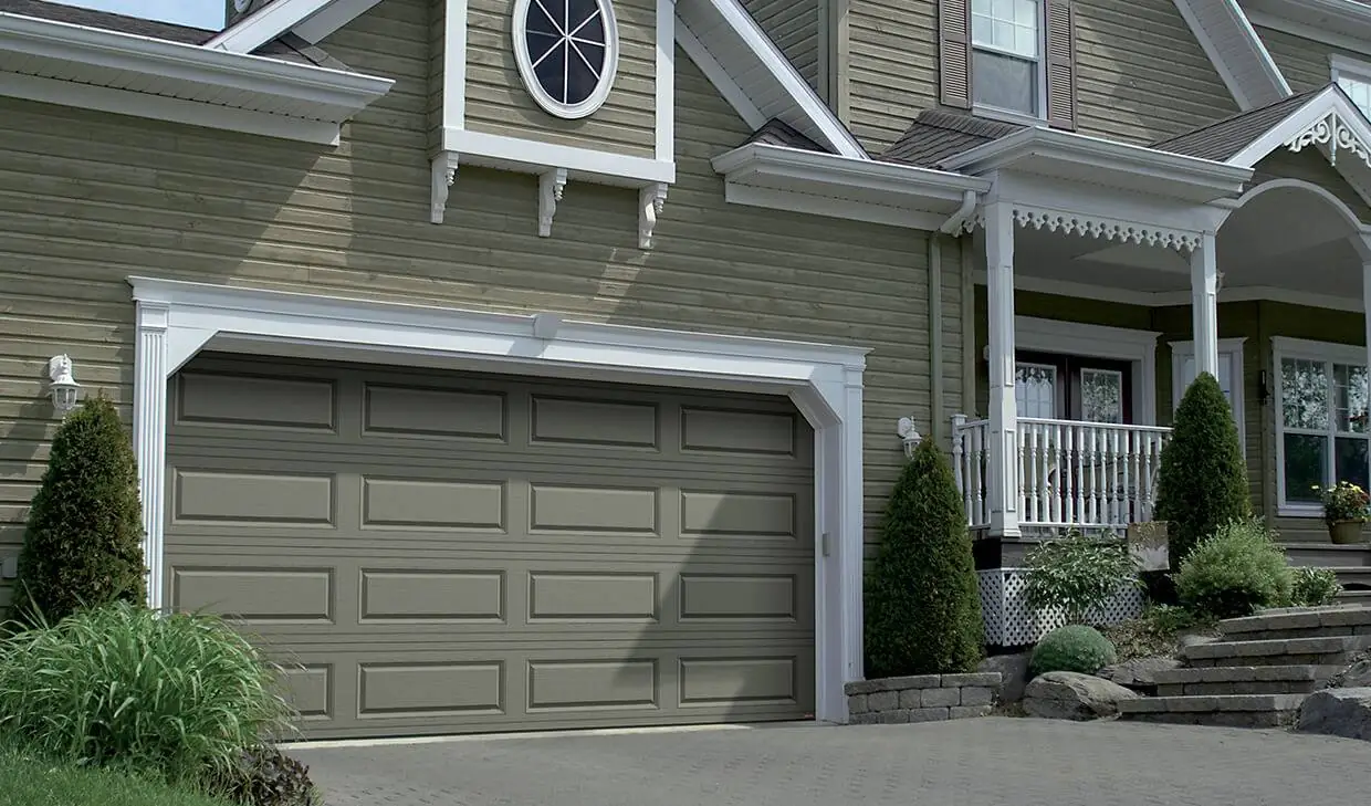 A steel garage door on a large tan home